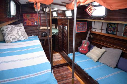 a room with two bunk beds and a guitar at San Blas Sailing Experience With Us! in El Porvenir