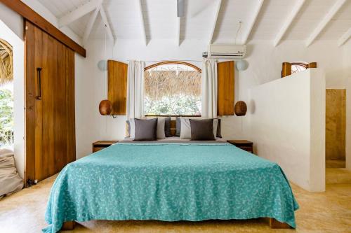 a bedroom with a large bed with a green blanket at Casa Picaflor in Las Terrenas