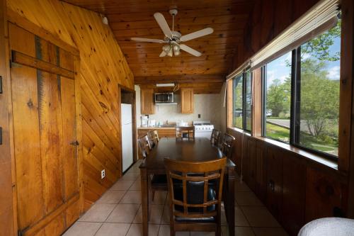a dining room with a table and a ceiling fan at Depe Dene Lakeside Resort in Lake George