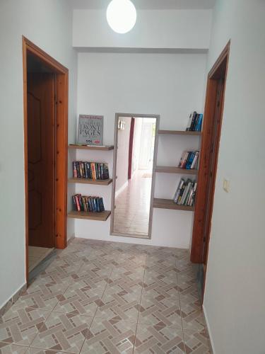 a hallway with a mirror and shelves with books at Villa Papa in Ksamil
