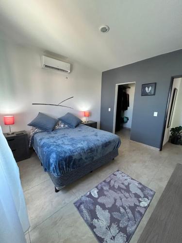 sypialnia z łóżkiem z niebieską pościelą i dywanem w obiekcie Apartment jacuzzi Ocean view w mieście Cabo San Lucas