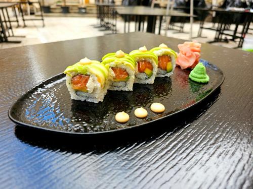 a black plate with sushi on a table at Luxury Rooms "Kaleta" in Trogir
