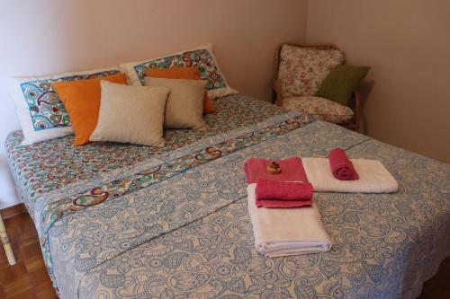 a bedroom with a bed with towels and a chair at Casa Basso in Loano