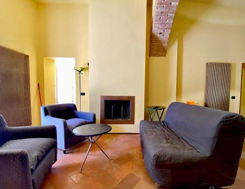 een woonkamer met een bank en stoelen en een open haard bij Perugia Abbraccio Etrusco in Perugia