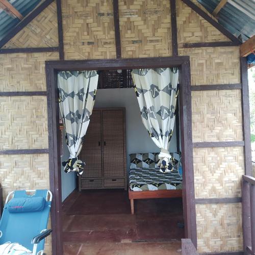 um quarto numa casa com cortinas e uma porta em Klay's tiny home em San Isidro