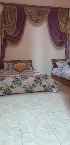 sypialnia z łóżkiem z fioletowymi zasłonami w obiekcie APARTAMENTOS NASSIRi w mieście Al-Ujun