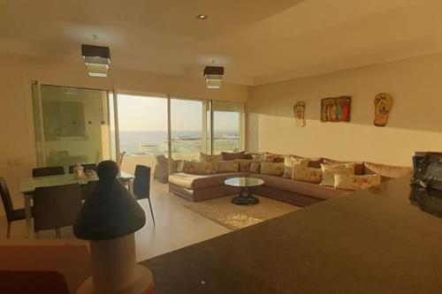 a living room with a couch and a table at Lujoso aprtamento cap tingis playa tanger in Tangier