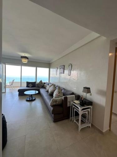 a living room with a couch and a table at Lujoso aprtamento cap tingis playa tanger in Tangier