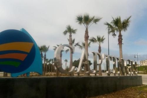 a sign in front of a park with palm trees at Lujoso aprtamento cap tingis playa tanger in Tangier