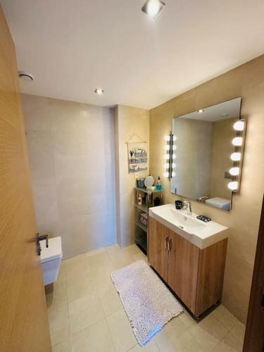a bathroom with a sink and a mirror at Lujoso aprtamento cap tingis playa tanger in Tangier