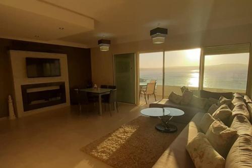 a living room with a couch and a table at Lujoso aprtamento cap tingis playa tanger in Tangier