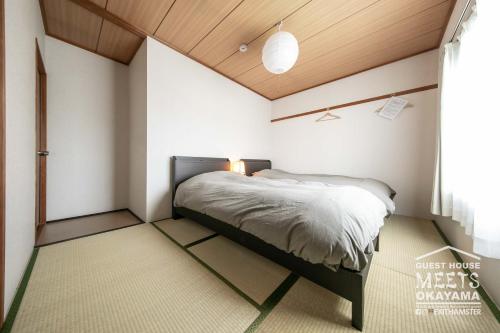um quarto com uma cama num quarto em Guest House MEETS Okayama 全室個室のホステル em Okayama
