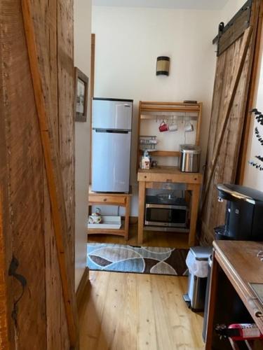 a kitchen with a refrigerator and a wooden floor at Cajun-Get Away in Breaux Bridge