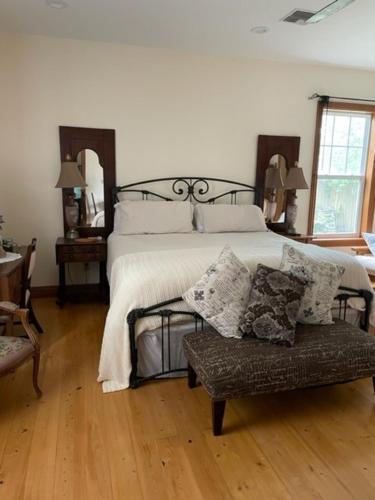 a bedroom with a bed and a bench with pillows at Cajun-Get Away in Breaux Bridge