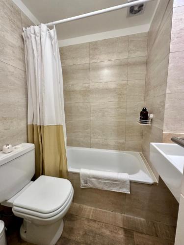 y baño con aseo, bañera y lavamanos. en Roma Apart Recoleta en Buenos Aires