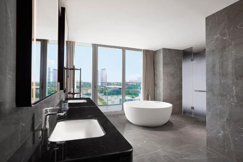 a bathroom with a white tub and a large window at Sheraton Rizhao Hotel in Rizhao