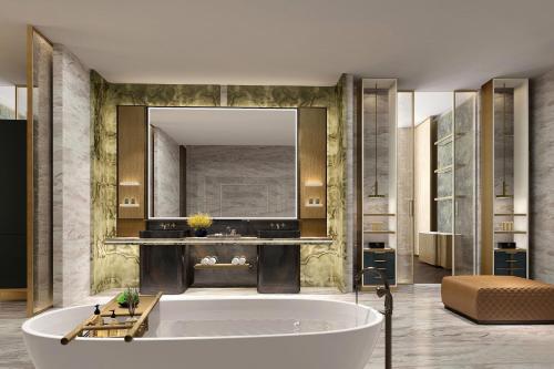 a bathroom with a tub and a large mirror at Sheraton Rizhao Hotel in Rizhao