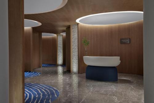 a bathroom with a tub and a sink in a room at Sheraton Rizhao Hotel in Rizhao