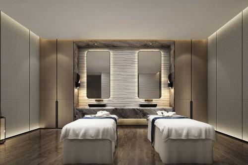 two beds in a room with two mirrors at Sheraton Rizhao Hotel in Rizhao
