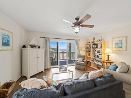 a living room with a couch and a ceiling fan at Island North 14C - 2nd row stunner! Relax in comfort after your days in the sun condo in Carolina Beach
