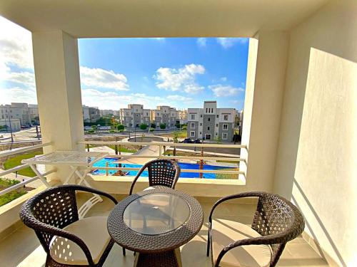 a balcony with a table and chairs and a view of a pool at Amwaj North Coast Q zone Second floor in El Alamein