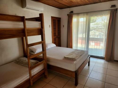 a bedroom with two bunk beds and a window at Hostel El Pretal in Liberia