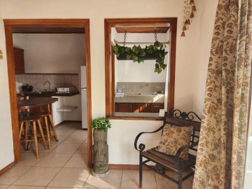 a living room with a chair and a kitchen at Hostel El Pretal in Liberia