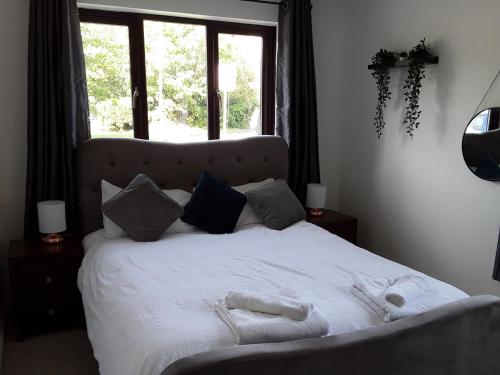 a bed with white sheets and pillows and a window at Impeccable 2-Bed Apartment in Grays London in Grays Thurrock