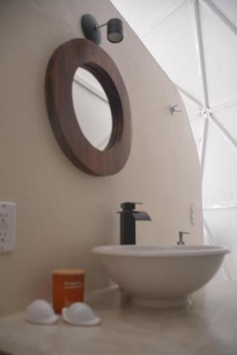 a bathroom with a sink and a mirror on the wall at Glamping Mayan Glam in Tulum