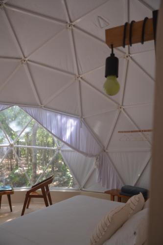 1 dormitorio con techo blanco y ventana en Glamping Mayan Glam, en Tulum