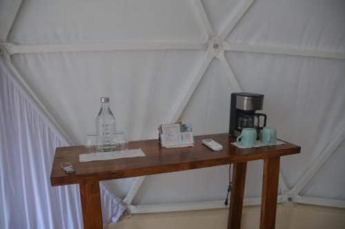 a wooden table with a coffee maker on it at Glamping Mayan Glam in Tulum