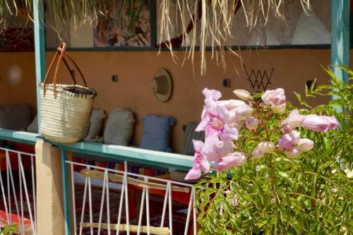 a table with pink flowers and a basket on it at The Madrassa Hostel in Marrakech
