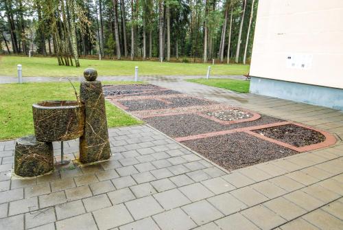 a statue of a person with a planter in a park at Royal SPA Residence in Birštonas