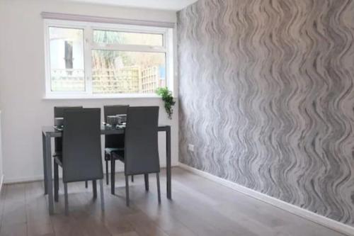 a dining room with a table and chairs against a wall at Large House - Free Parking - Contractor - Leisure in Luton
