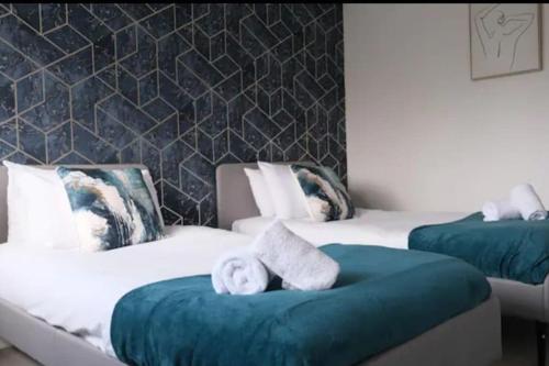 - une chambre avec 2 lits et des serviettes dans l'établissement Large House - Free Parking - Contractor - Leisure, à Luton