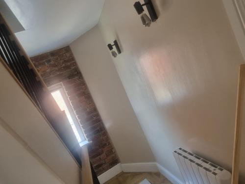 a hallway with a staircase with a brick wall at Grade ll listed holiday home in Llanidloes