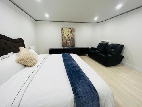 a bedroom with a bed and a black leather couch at New 2 bedrooms King & Queen beds Guest suite in Surrey
