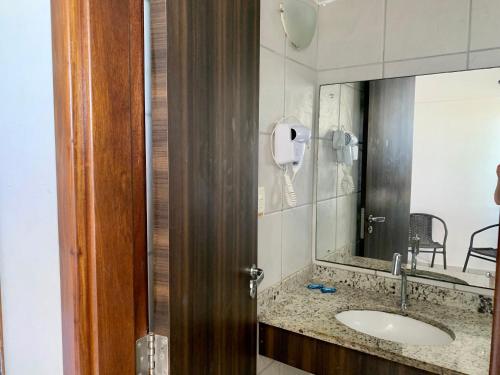 un baño con lavabo y espejo en Flat em Ponta Negra Natal/RN, en Natal