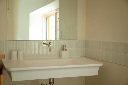 a white sink in a bathroom with a mirror at Shiroyamakan in Shirakawa