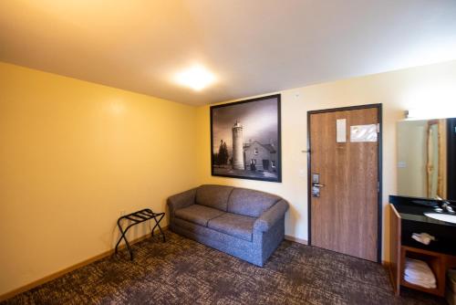 a living room with a couch and a picture on the wall at Super 8 by Wyndham Bridgeview of Mackinaw City in Mackinaw City