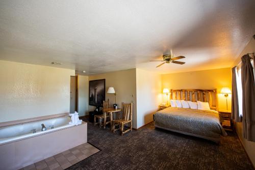 a hotel room with a bed and a bath tub at Super 8 by Wyndham Bridgeview of Mackinaw City in Mackinaw City