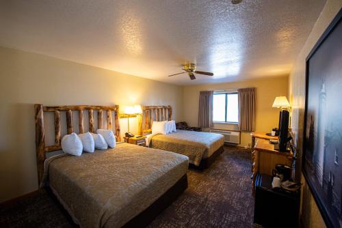 a hotel room with two beds and a window at Super 8 by Wyndham Bridgeview of Mackinaw City in Mackinaw City