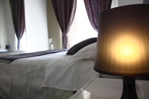 1 dormitorio con 1 cama y 1 mesa con lámpara en Casa Lucia, en Taormina