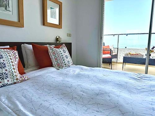 a bedroom with a bed with a view of the beach at Prestigieux Appartement à Marina Assilah Golf in Asilah