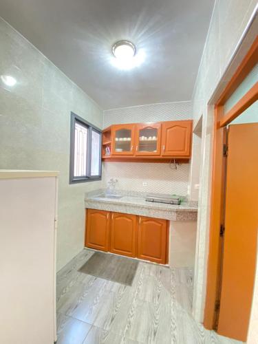 an empty kitchen with orange cabinets and a window at Ayyur in Agadir