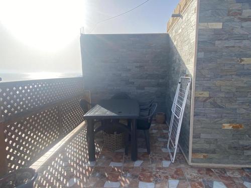 a small table on a balcony with a brick wall at Ayyur in Agadir