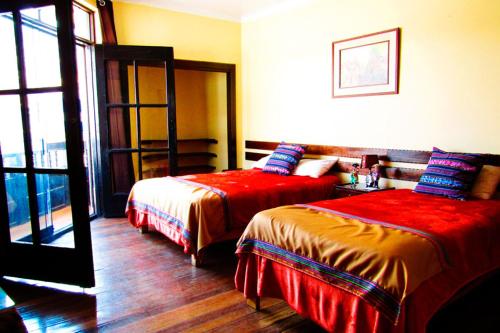 a hotel room with two beds and a window at Hospedaje Balcón Cusqueño in Cusco