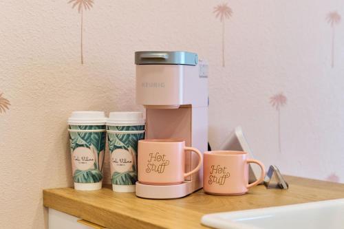 a coffee maker and three coffee cups on a counter at Luxury Villa 3 Blocks from the Beach with Pool a Fire Pit and Outdoor Oasis in Cape Canaveral
