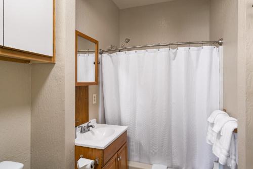 a bathroom with a white shower curtain and a sink at Alpine #2 in West Yellowstone