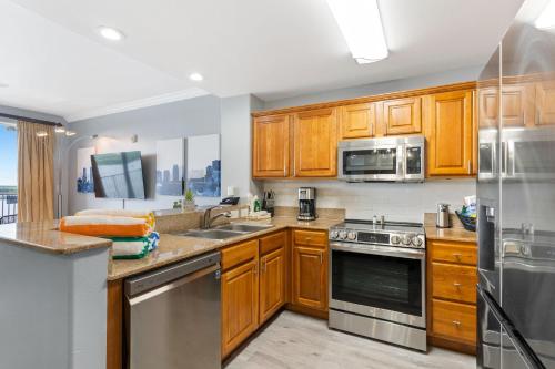 a kitchen with wooden cabinets and stainless steel appliances at Blue Heron Beach Resort in Orlando